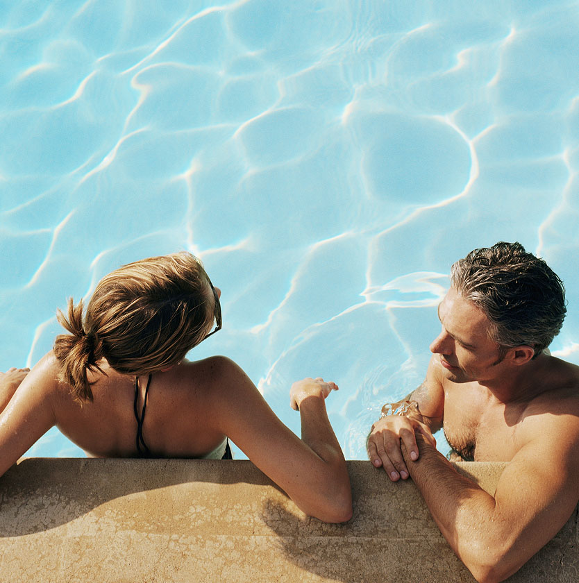 A couple chats while in a swimming pool