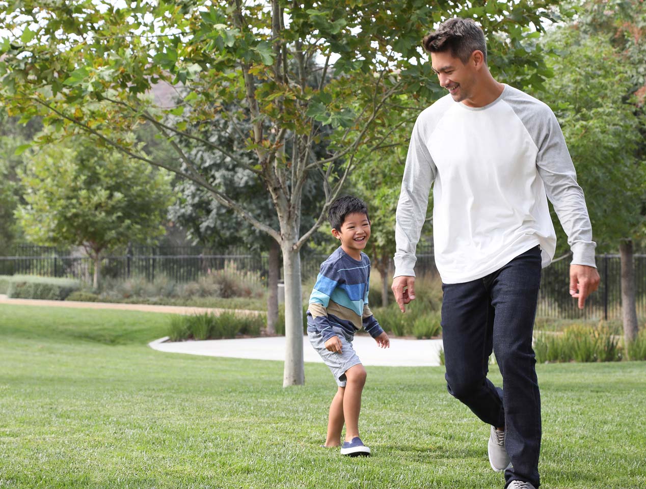 A man and his son play in a park
