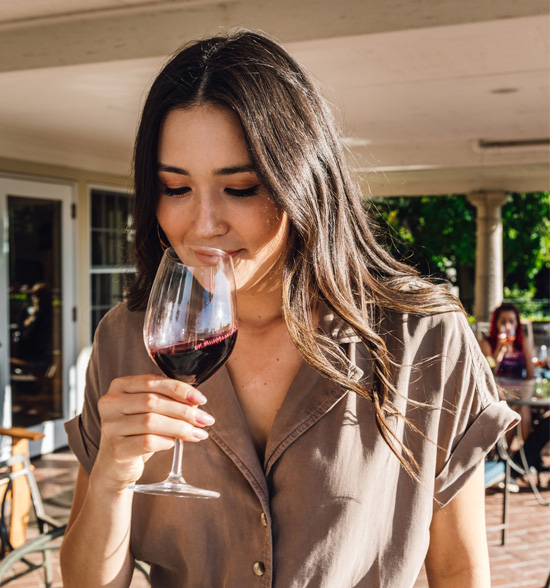 A woman smells a glass of wine